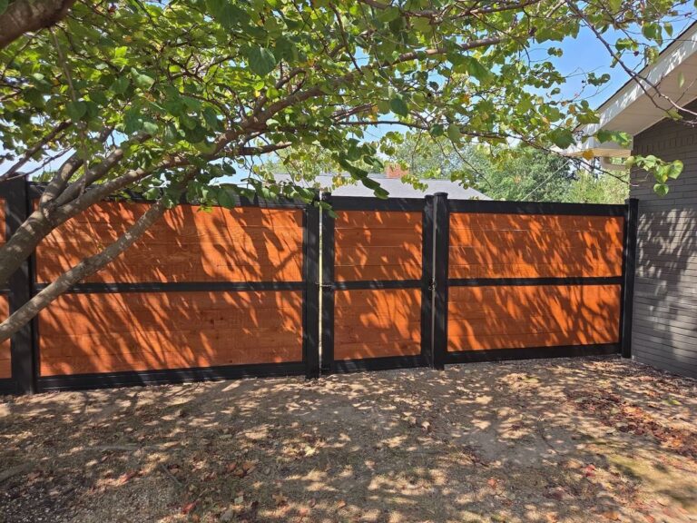 Close-up of stained horizontal cedar fence panels and gate with black metal trim